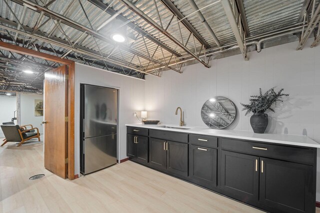 4326 Taylor Ave, Mount Pleasant, WI 53405 - kitchen with freestanding refrigerator, light countertops, dark cabinetry, and light wood-style flooring