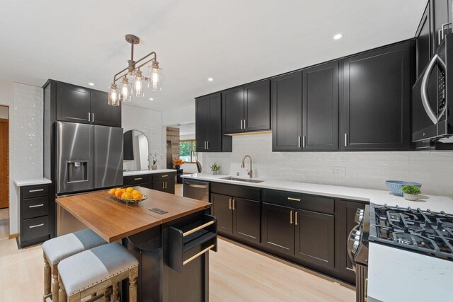 4326 Taylor Ave, Mount Pleasant, WI 53405 - kitchen with wooden counters, tasteful backsplash, dark cabinets, appliances with stainless steel finishes, and decorative light fixtures