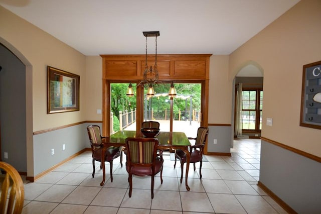 551 Bayberry Ln, Slinger, WI 53086 - dining space with arched walkways, light tile patterned floors, and a chandelier