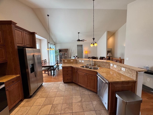 4126 Westerfield Ln, Madison, WI 53704 - kitchen featuring appliances with stainless steel finishes, a ceiling fan, a chandelier, open floor plan, and light stone countertops