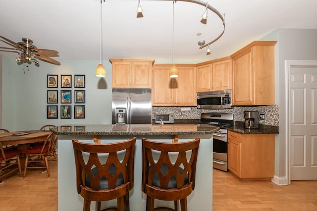 1515 N Van Buren St Unit 414, Milwaukee, WI 53202 - kitchen with stainless steel appliances, light brown cabinets, tasteful backsplash, and a ceiling fan