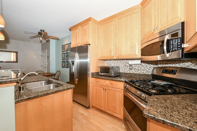 1515 N Van Buren St Unit 414, Milwaukee, WI 53202 - kitchen featuring appliances with stainless steel finishes, light brown cabinetry, light wood finished floors, and decorative backsplash