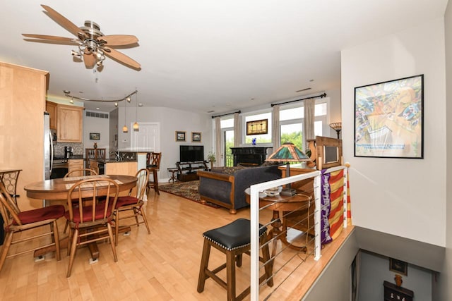1515 N Van Buren St Unit 414, Milwaukee, WI 53202 - dining area featuring light wood-style floors, ceiling fan, and a fireplace