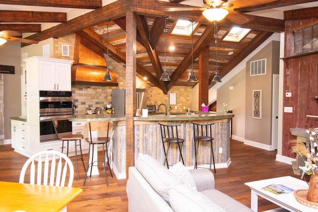 890 Windsor Dr Unit 4, Fontana, WI 53125 - kitchen with stainless steel appliances, a ceiling fan, tasteful backsplash, a kitchen breakfast bar, and white cabinetry