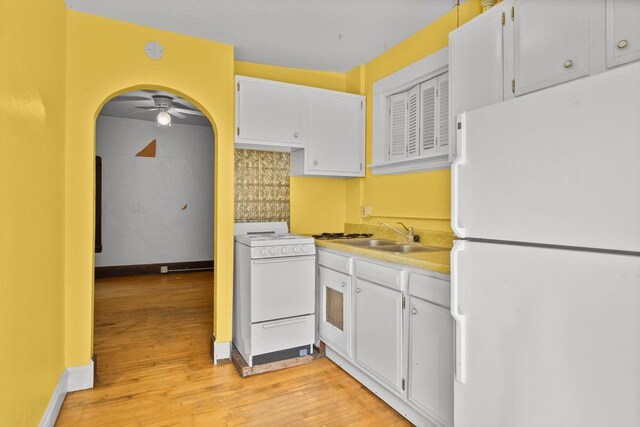 1049 E Johnson St, Madison, WI 53703 - kitchen with white appliances, arched walkways, light wood-type flooring, white cabinetry, and light countertops