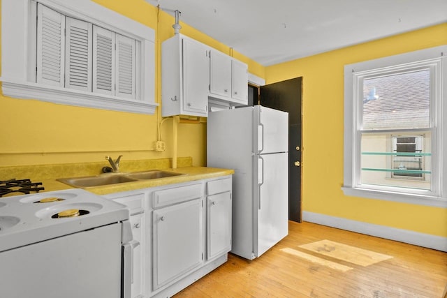 1049 E Johnson St, Madison, WI 53703 - kitchen featuring white appliances, light wood-style floors, light countertops, and white cabinets