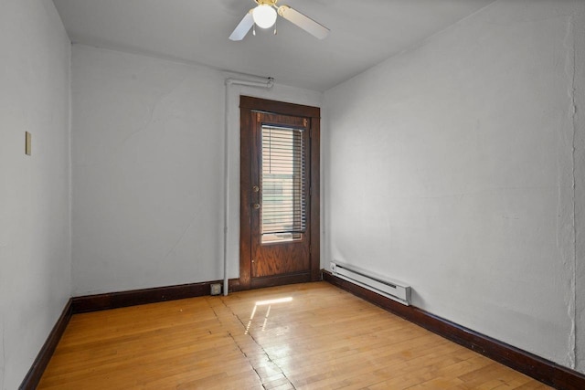 1049 E Johnson St, Madison, WI 53703 - unfurnished room featuring a baseboard heating unit, light wood finished floors, and a ceiling fan