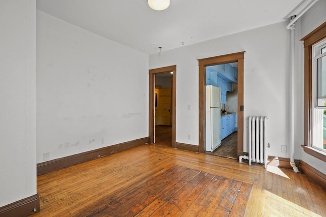 1049 E Johnson St, Madison, WI 53703 - unfurnished room featuring radiator heating unit and wood-type flooring