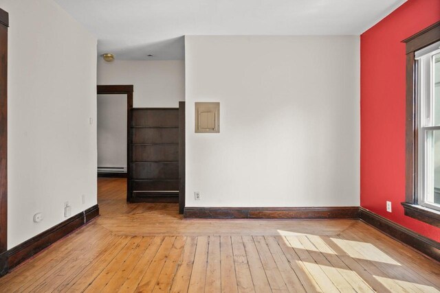 1049 E Johnson St, Madison, WI 53703 - spare room with wood-type flooring, plenty of natural light, a baseboard radiator, and electric panel