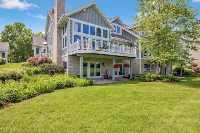 1223 Milwaukee St Unit B, Delafield, WI 53018 - back of house featuring a lawn, a chimney, french doors, brick siding, and a deck