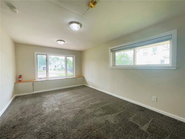 628 W Cedar St, Chippewa Falls, WI 54729 - unfurnished room with healthy amount of natural light, a smoke detector, and dark colored carpet