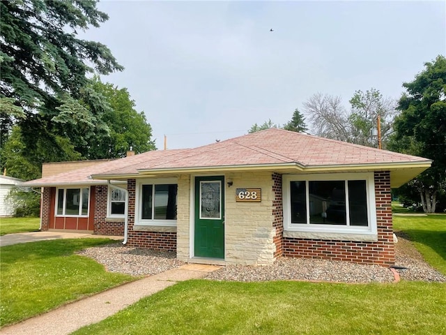 628 W Cedar St, Chippewa Falls, WI 54729 - view of front of home featuring a front lawn, brick siding, and a shingled roof