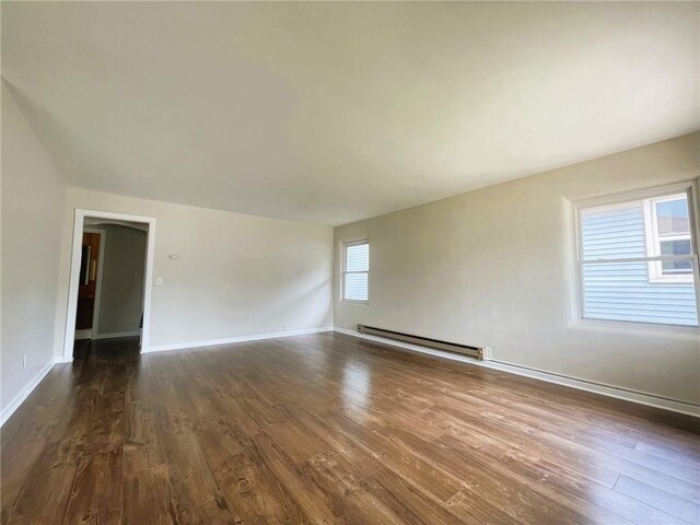 628 W Cedar St, Chippewa Falls, WI 54729 - empty room featuring a baseboard heating unit and dark wood finished floors