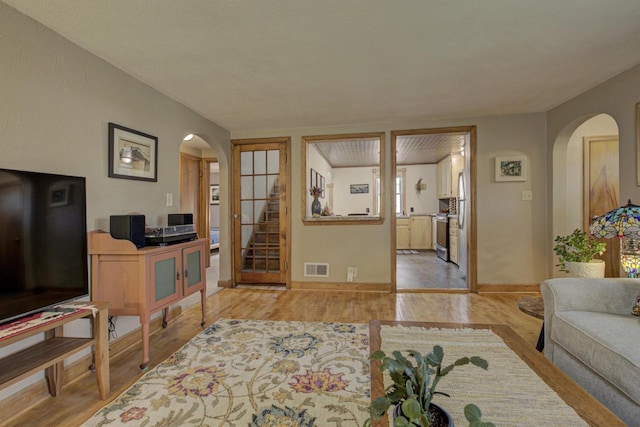 318 N Outagamie St, Appleton, WI 54914 - living area with arched walkways, wood finished floors, and stairway