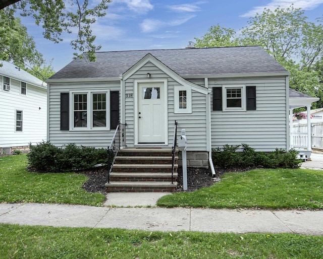 318 N Outagamie St, Appleton, WI 54914 - view of front of home featuring entry steps, roof with shingles, and a front yard