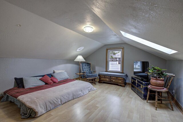 318 N Outagamie St, Appleton, WI 54914 - bedroom with a skylight, wood finished floors, a textured ceiling, and lofted ceiling