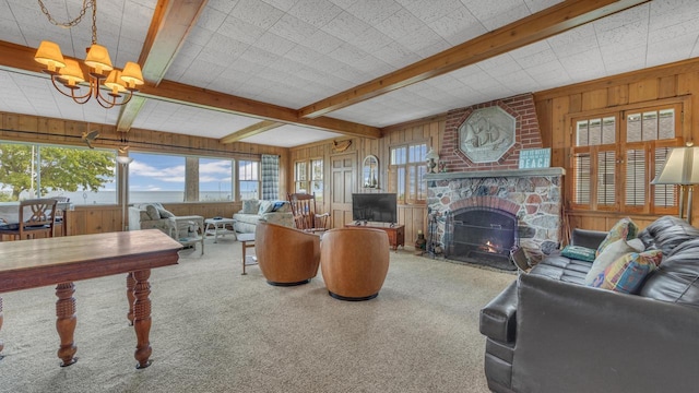 N133 Surfside Dr, Cedar Grove, WI 53013 - carpeted living room featuring wood walls, plenty of natural light, a chandelier, a large fireplace, and beamed ceiling