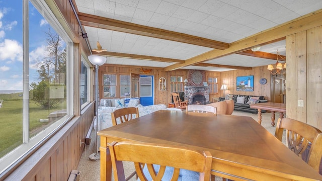 N133 Surfside Dr, Cedar Grove, WI 53013 - dining area with wood walls, beam ceiling, plenty of natural light, a fireplace, and a chandelier