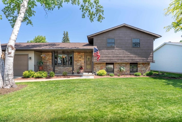 1360 Eminence St, Green Bay, WI 54313 - tri-level home featuring covered porch, a garage, a front yard, and stone siding