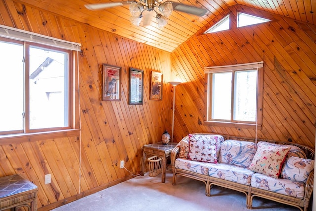 N8244 Woodland Trl, New Lisbon, WI 53950 - living room featuring ceiling fan, healthy amount of natural light, wooden walls, vaulted ceiling, and carpet floors