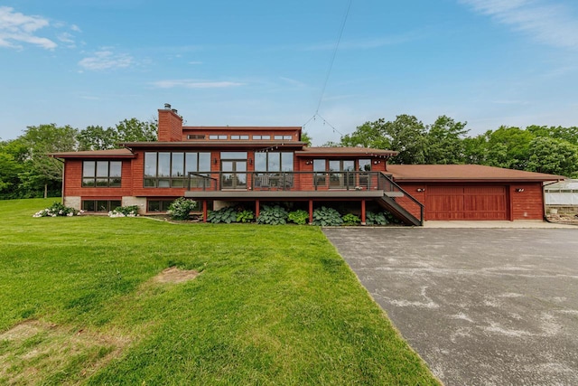W301S1487 Brandybrook Rd, Waukesha, WI 53188 - back of house featuring a lawn, a chimney, a wooden deck, driveway, and an attached garage