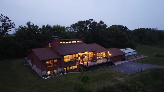 W301S1487 Brandybrook Rd, Waukesha, WI 53188 - back of property with a lawn, driveway, a chimney, and an attached garage