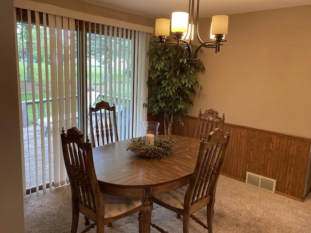 3988 S 18th St, Sheboygan, WI 53081 - carpeted dining area with healthy amount of natural light, a chandelier, wainscoting, and wooden walls