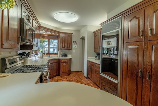1329 23rd Ave, Monroe, WI 53566 - kitchen featuring stainless steel range with gas stovetop, light tile patterned floors, built in refrigerator, and light countertops