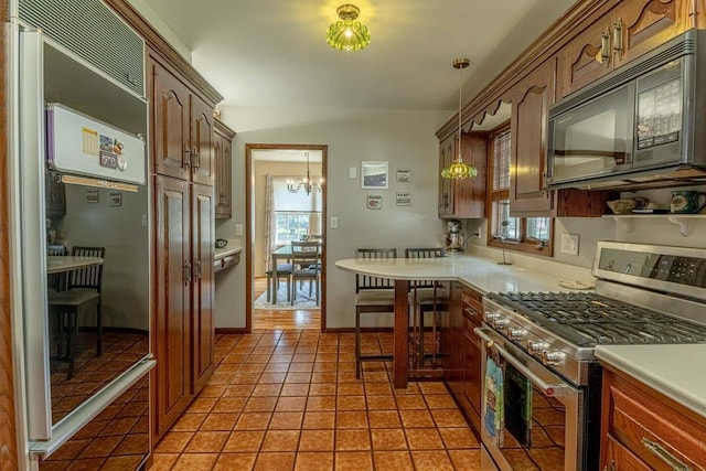1329 23rd Ave, Monroe, WI 53566 - kitchen featuring stainless steel appliances, light tile patterned flooring, a chandelier, light countertops, and hanging light fixtures