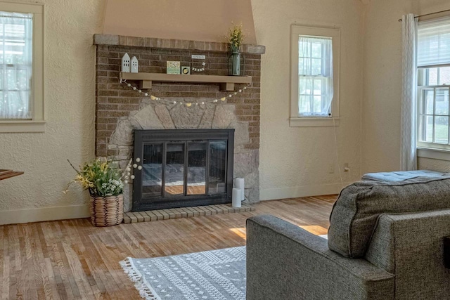 1329 23rd Ave, Monroe, WI 53566 - living area featuring wood finished floors, a brick fireplace, and a textured wall