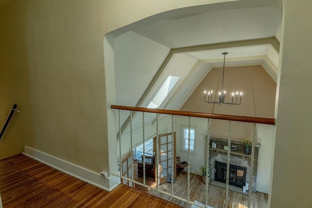 1329 23rd Ave, Monroe, WI 53566 - detailed view of a chandelier, wood finished floors, a premium fireplace, a skylight, and arched walkways