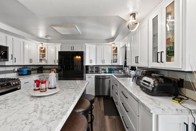 1664 Spruce St, Green Bay, WI 54304 - kitchen with appliances with stainless steel finishes, white cabinetry, tasteful backsplash, and dark wood-style flooring