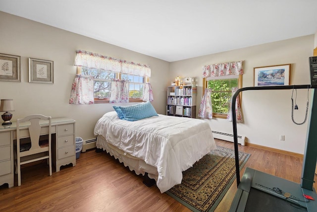 435 S Main St, Markesan, WI 53946 - bedroom featuring a baseboard heating unit, multiple windows, and wood finished floors