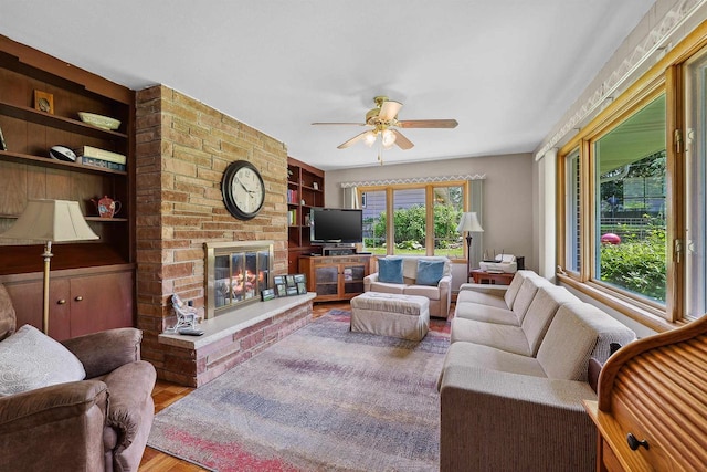435 S Main St, Markesan, WI 53946 - living room featuring a ceiling fan, built in features, a fireplace, and wood finished floors