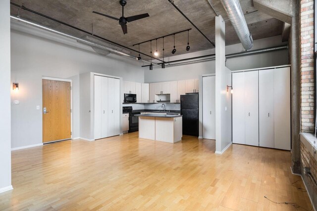 1924 N Hubbard St Unit 109, Milwaukee, WI 53212 - kitchen with black appliances, a high ceiling, light wood finished floors, white cabinetry, and ceiling fan