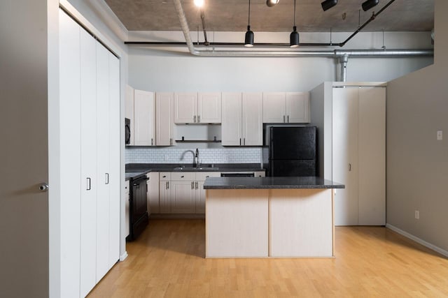 1924 N Hubbard St Unit 109, Milwaukee, WI 53212 - kitchen featuring black appliances, dark countertops, light wood-type flooring, and tasteful backsplash