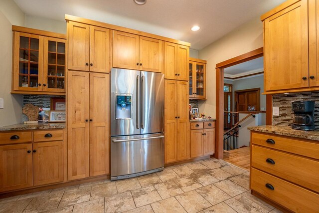 303 Rimrock Rd, Wausau, WI 54401 - kitchen featuring stainless steel refrigerator with ice dispenser, decorative backsplash, stone countertops, glass insert cabinets, and recessed lighting
