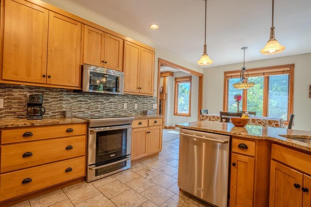303 Rimrock Rd, Wausau, WI 54401 - kitchen with appliances with stainless steel finishes, decorative backsplash, pendant lighting, light stone counters, and recessed lighting
