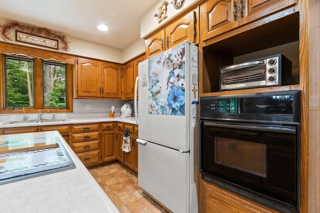 2929 Brunner Rd, Manitowoc, WI 54220 - kitchen featuring freestanding refrigerator, oven, light countertops, brown cabinetry, and recessed lighting