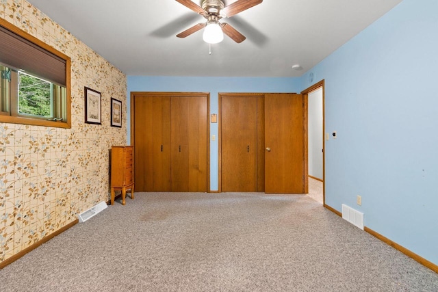 2929 Brunner Rd, Manitowoc, WI 54220 - unfurnished bedroom featuring multiple closets, carpet floors, and a ceiling fan