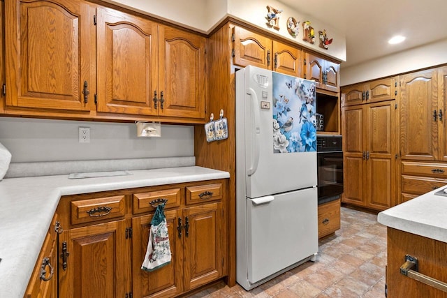 2929 Brunner Rd, Manitowoc, WI 54220 - kitchen featuring freestanding refrigerator, black oven, and brown cabinets