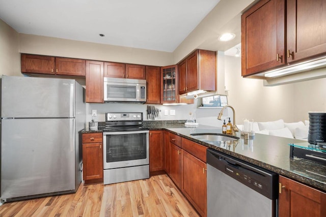 234 N Broadway Unit 402, Milwaukee, WI 53202 - kitchen with stainless steel appliances, light wood finished floors, and dark stone countertops