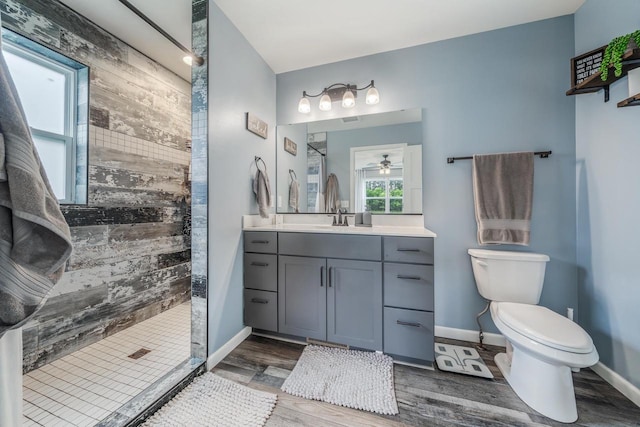 N3366 Flynn Dr, Montello, WI 53949 - full bathroom with a tile shower, wood finished floors, vanity, wood walls, and ceiling fan