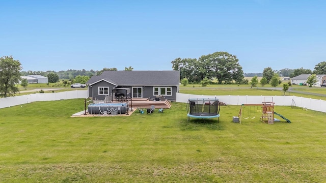 N3366 Flynn Dr, Montello, WI 53949 - rear view of house with a trampoline, a deck, a playground, and a fenced backyard