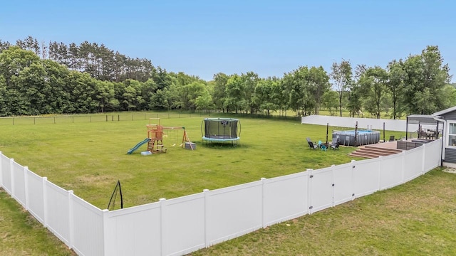 N3366 Flynn Dr, Montello, WI 53949 - view of home's community with a trampoline, a playground, a fenced backyard, and view of scattered trees