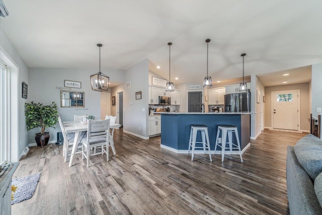N3366 Flynn Dr, Montello, WI 53949 - kitchen featuring appliances with stainless steel finishes, white cabinets, a chandelier, dark wood-style flooring, and vaulted ceiling