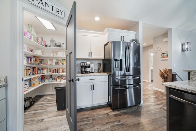 N3366 Flynn Dr, Montello, WI 53949 - kitchen featuring stainless steel fridge with ice dispenser, dishwasher, wood finished floors, white cabinets, and light stone countertops