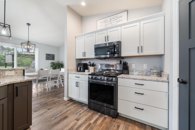 N3366 Flynn Dr, Montello, WI 53949 - kitchen featuring stainless steel appliances, light wood-type flooring, white cabinets, a chandelier, and vaulted ceiling