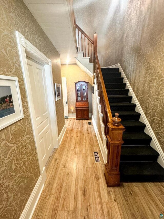 303 E 5th St, Washburn, WI 54891 - staircase featuring wallpapered walls and wood finished floors