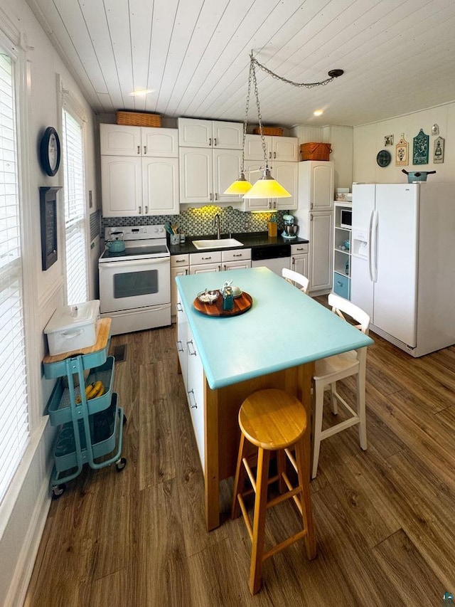 303 E 5th St, Washburn, WI 54891 - kitchen featuring white appliances, wooden ceiling, dark wood-style flooring, a center island, and decorative backsplash
